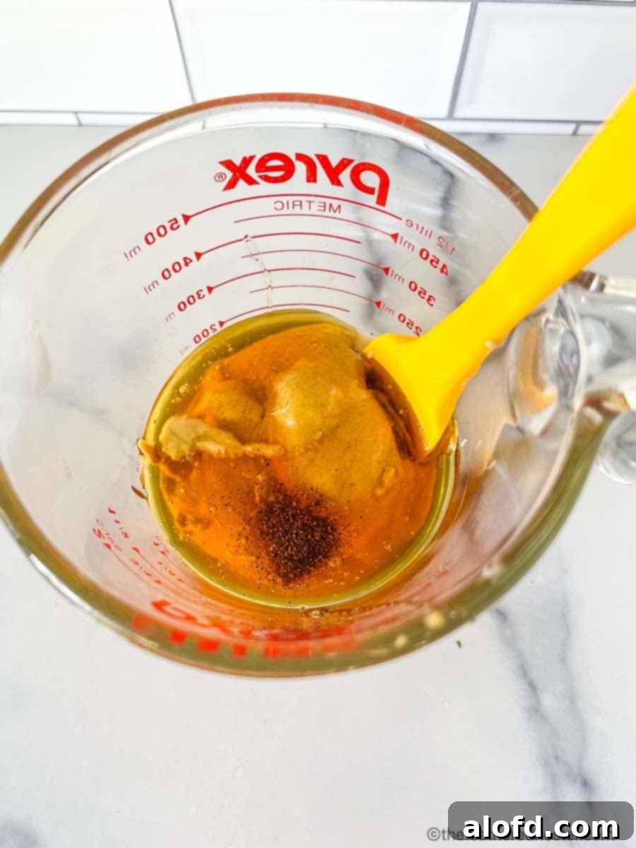 Zesty Honey Mustard Sauce 6 Raw liquid ingredients of Dijon mustard, mayonnaise, honey, and cayenne pepper ready to be stirred into spicy honey mustard.