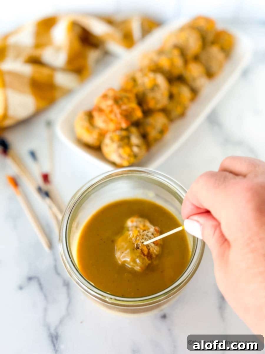 Zesty Honey Mustard Sauce 8 Dipping turkey meatballs into a spicy honey mustard sauce in a clear Weck jar.