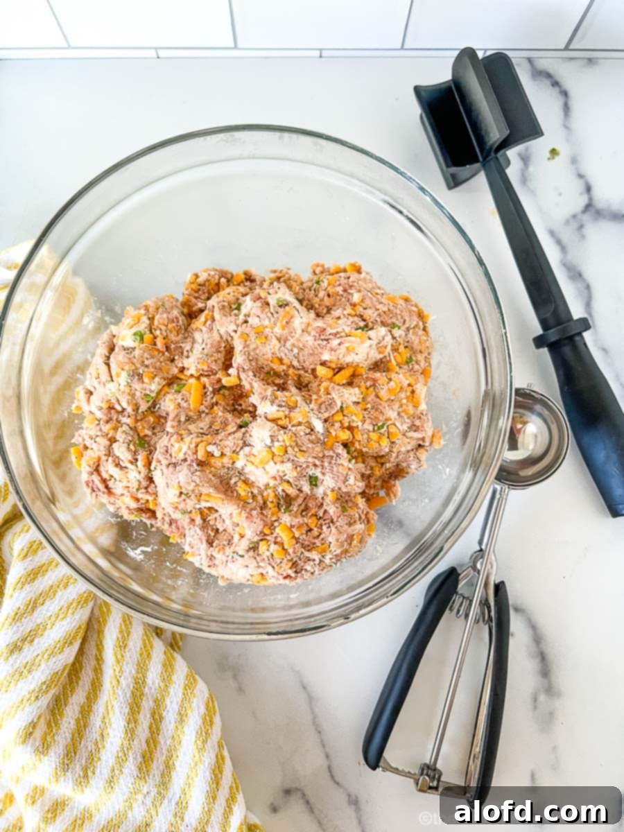 Savory Turkey Sausage Bites 5 A clear bowl with uncooked turkey sausage meatball mixture.