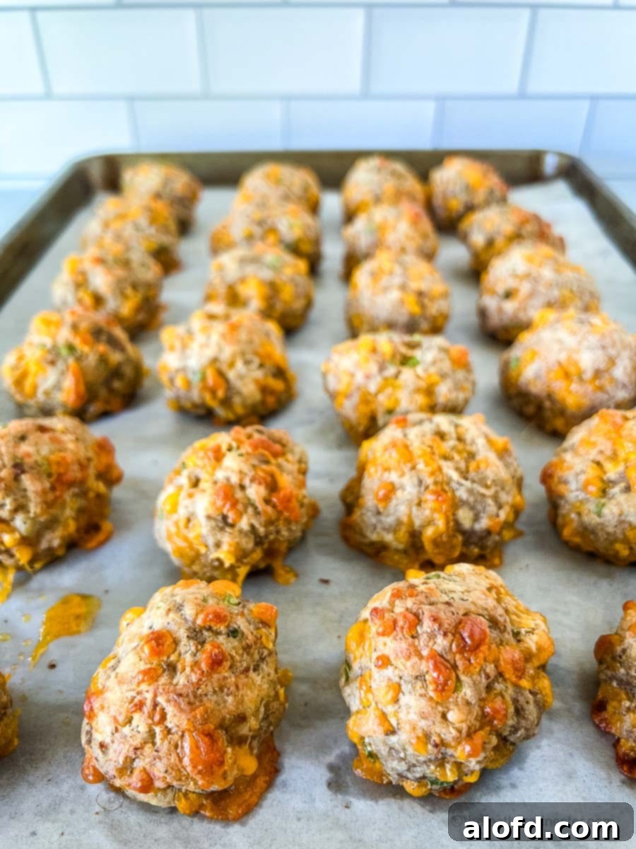 Savory Turkey Sausage Bites 10 A closeup of baked ground turkey balls on a parchment lined baking sheet.