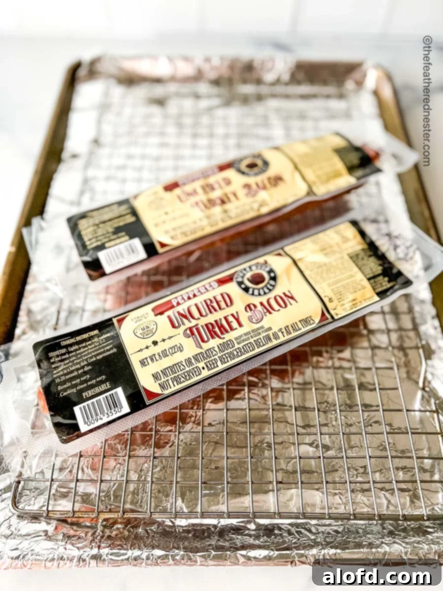 Crispy Oven Turkey Bacon 4 bacon on top of a baking rack and a baking sheet lined in foil.