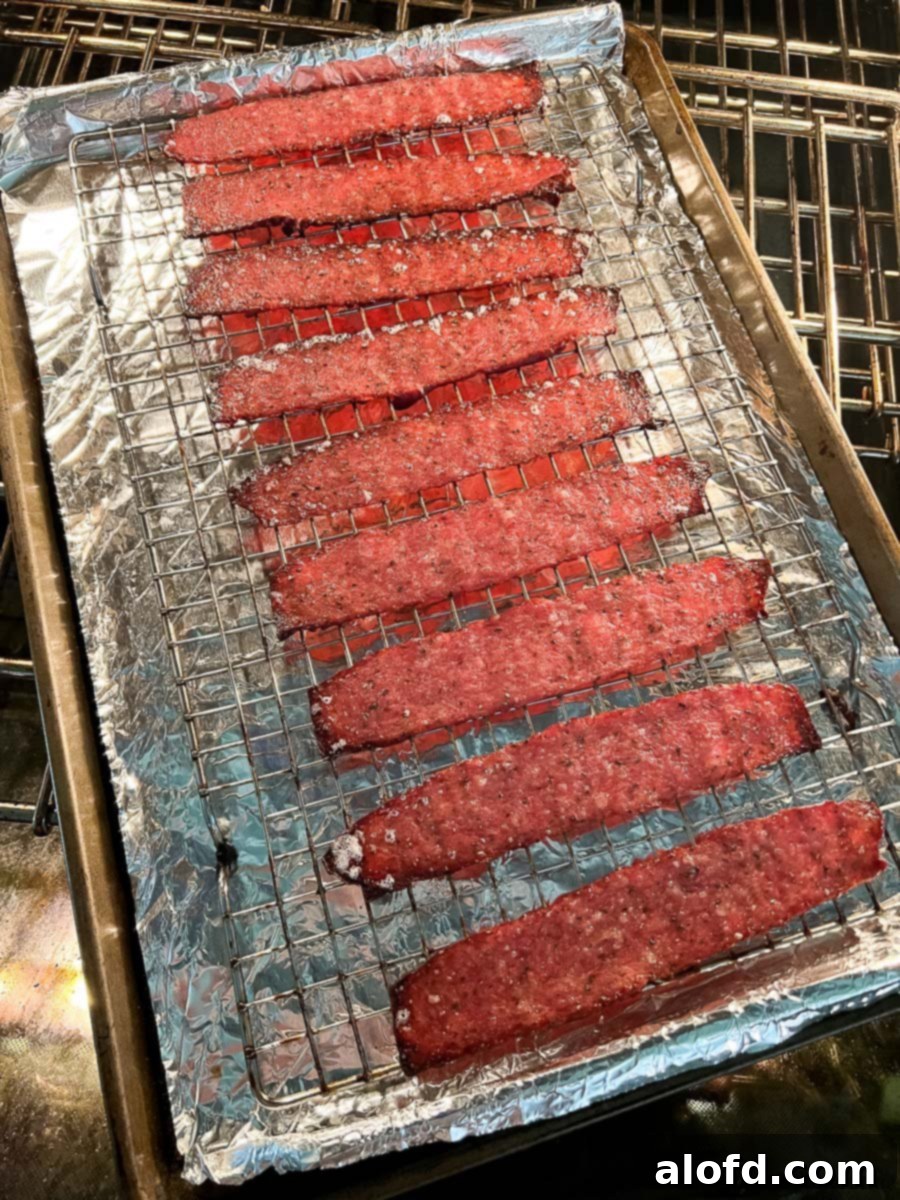 Crispy Oven Turkey Bacon 6 a baking rack over a baking sheet lined with foil and strips of turkey bacon.