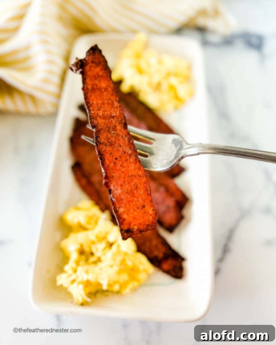 Crispy Oven Turkey Bacon 7 a white platter with oven baked turkey bacon and scrambled eggs.