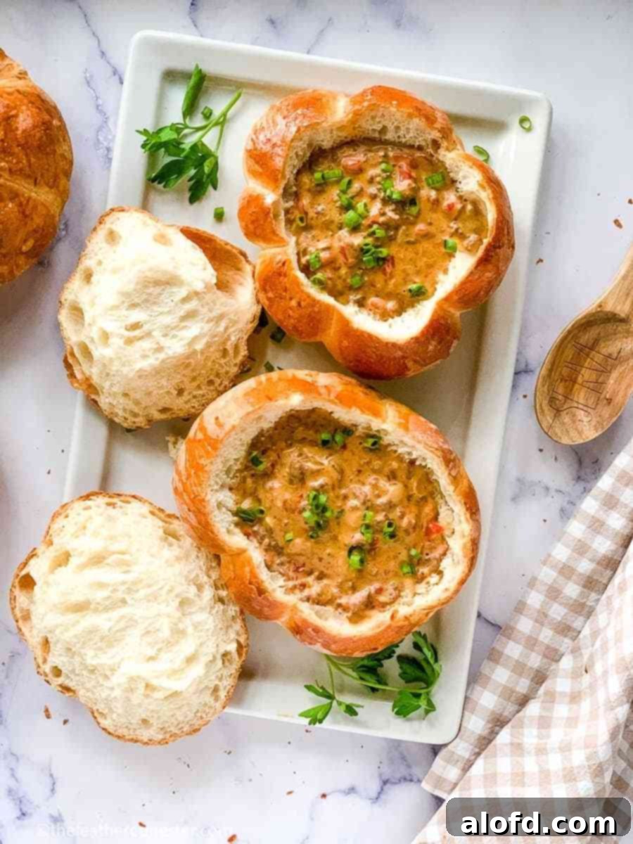 Cozy Soup Delights 3 A festive display of pumpkin-shaped bread bowls, each generously filled with a creamy and savory Cheeseburger soup, perfect for a cozy autumn meal.
