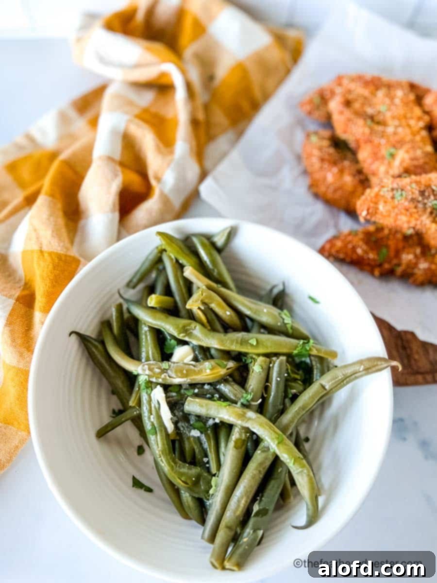 Quick and Tender Instant Pot Green Beans 8 Instant pot fresh green beans in a bowl with shake and bake chicken tenders and yellow cloth in the background.