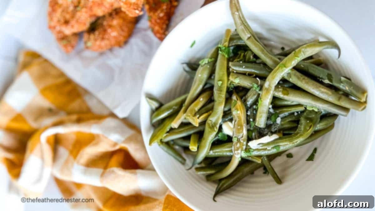 Quick and Tender Instant Pot Green Beans 9 Horizontal photo of instant pot fresh green beans in a bowl with shake and bake chicken tenders and yellow cloth in the background.
