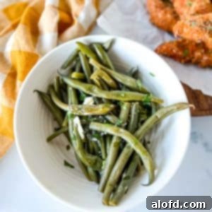 Quick and Tender Instant Pot Green Beans 10 Steamed green beans in a bowl with a yellow gingham check linen napkin in the background.