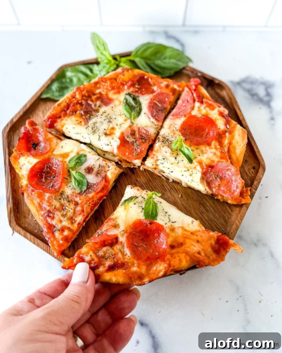 Flame-Kissed Pizza 12 A hand reaching for a slice of freshly grilled pizza on a wooden plate with basil garnish.