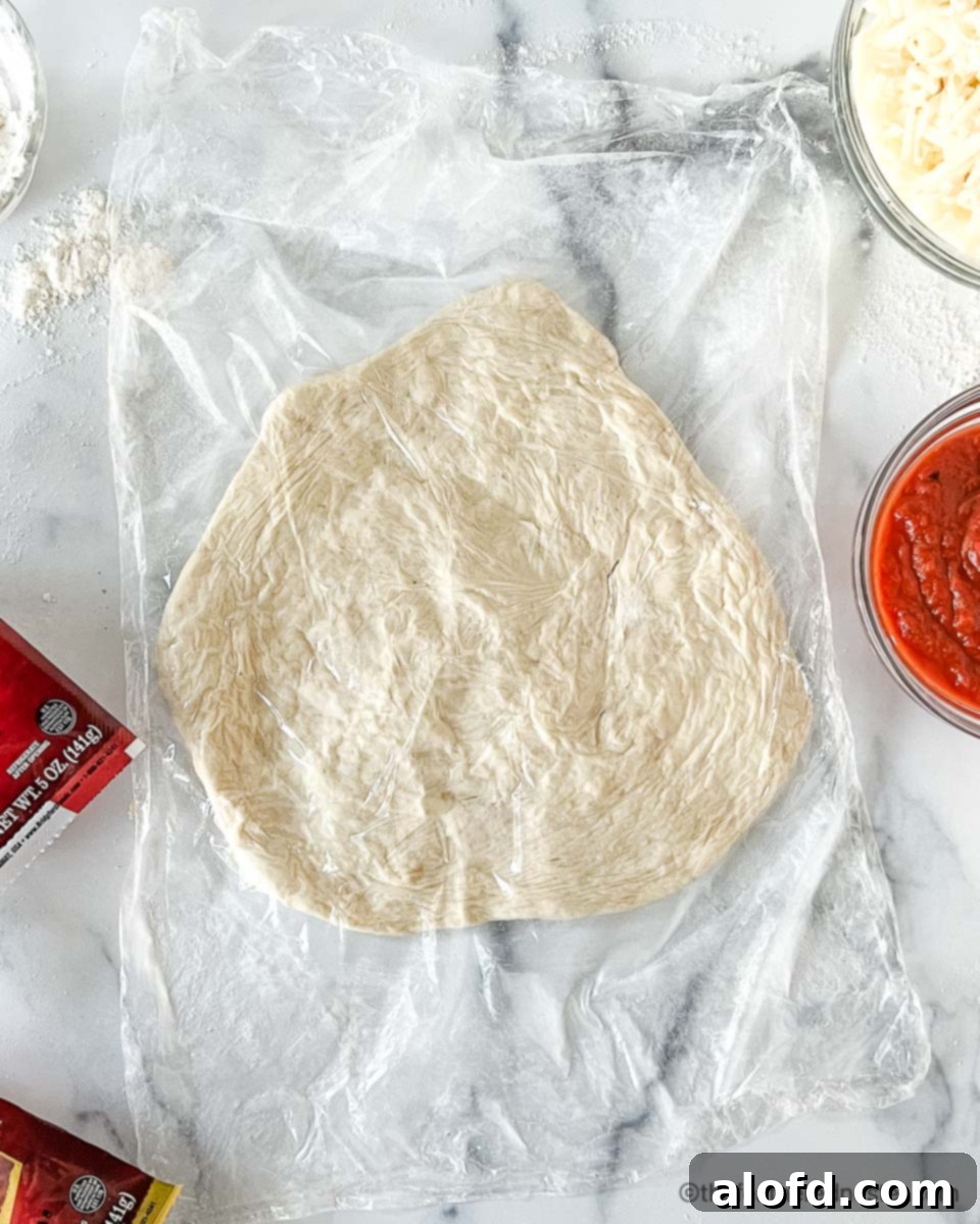 Flame-Kissed Pizza 7 A perfectly shaped pizza crust resting on a floured surface, ready for grilling.