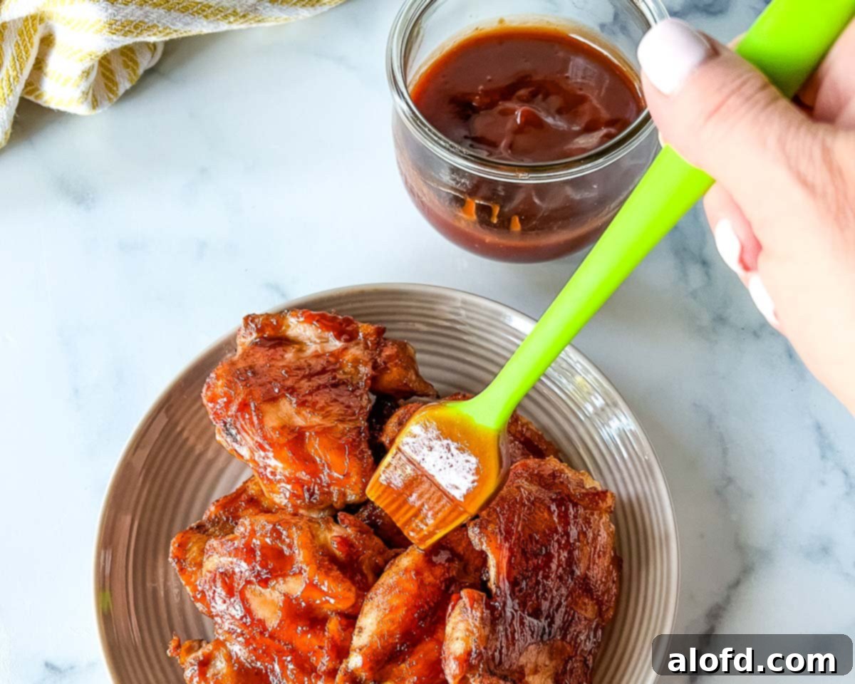 Basting the 3 Ingredient Homemade Honey BBQ Sauce on chicken.