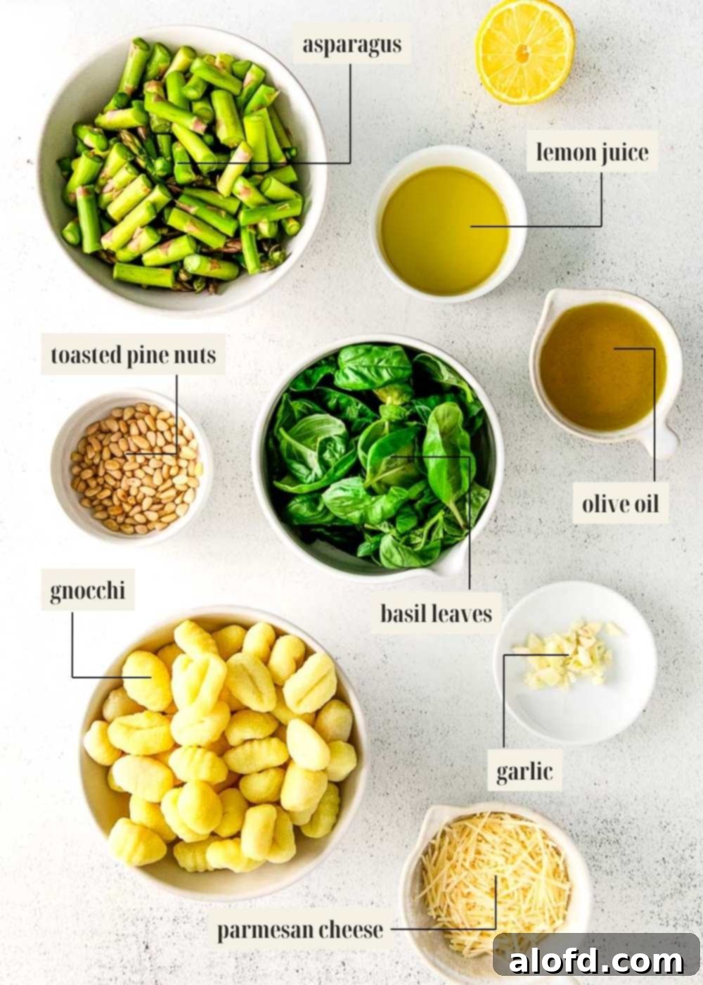 Labeled ingredients image for pesto gnocchi, showcasing fresh basil, asparagus, gnocchi, and pine nuts.