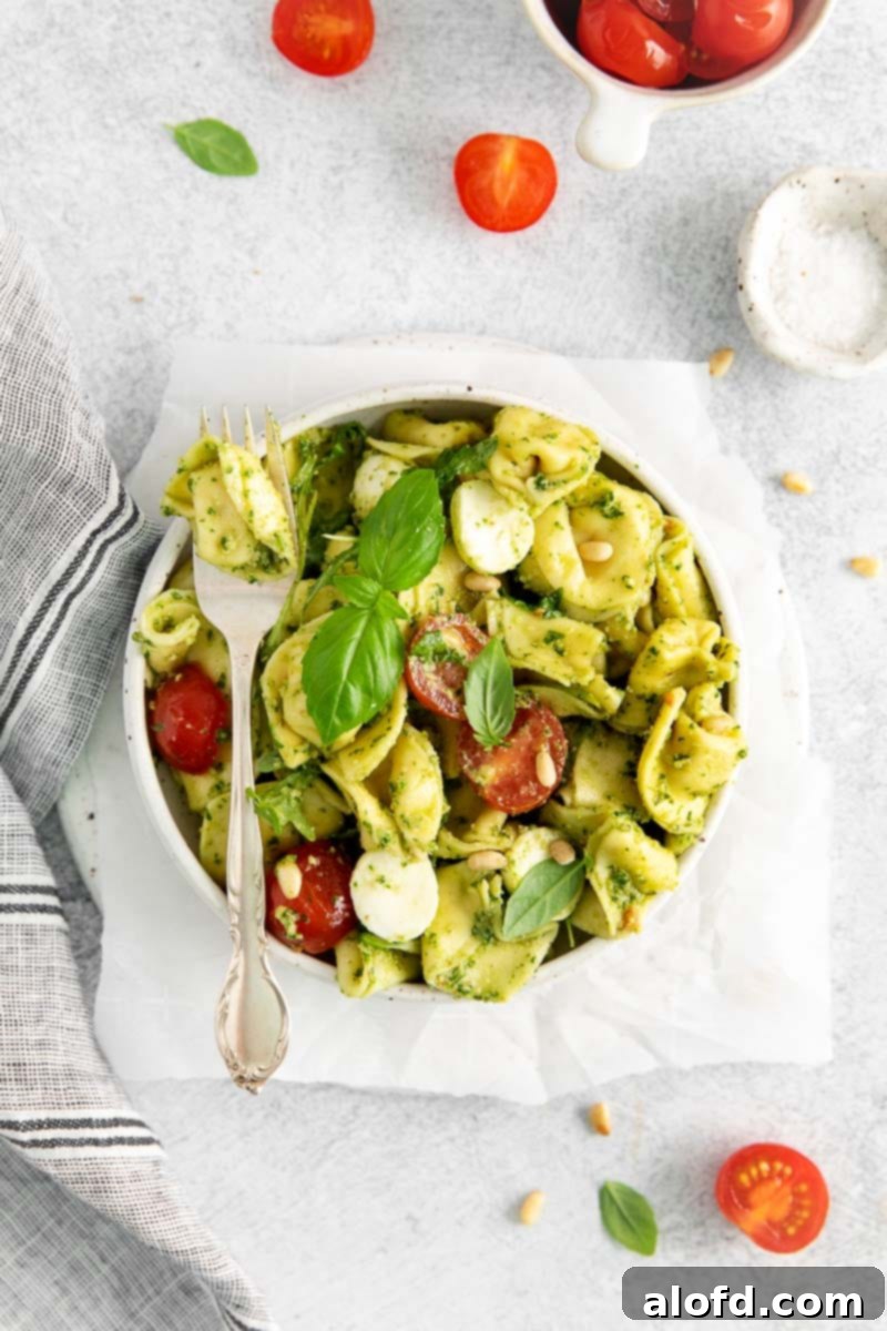 Pesto Tortellini Perfection 2 Tortellini Pasta Salad in a bowl with a fork laying over the top.