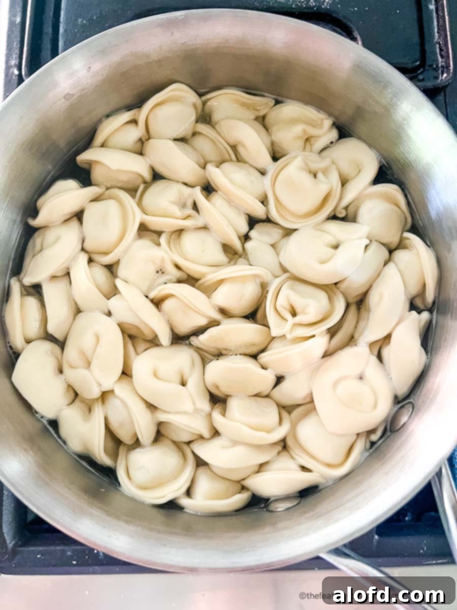 Caprese Tortellini Poppers 6 Tortellini pasta cooking in a sauce pan