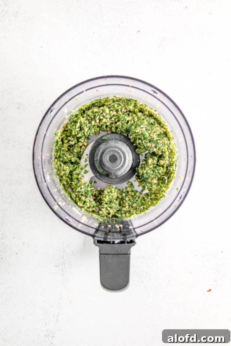 Emerald Herb Pesto 5 Fresh basil leaves and grated Parmesan cheese added to the mixture of toasted pine nuts and garlic in a food processor, ready for the next blending stage.