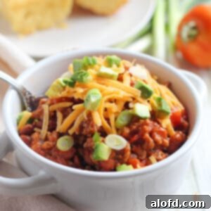 Hearty Skillet Chili 9 Soup bowl filled with homemade stovetop chili, garnished with shredded cheddar cheese and chopped scallions.