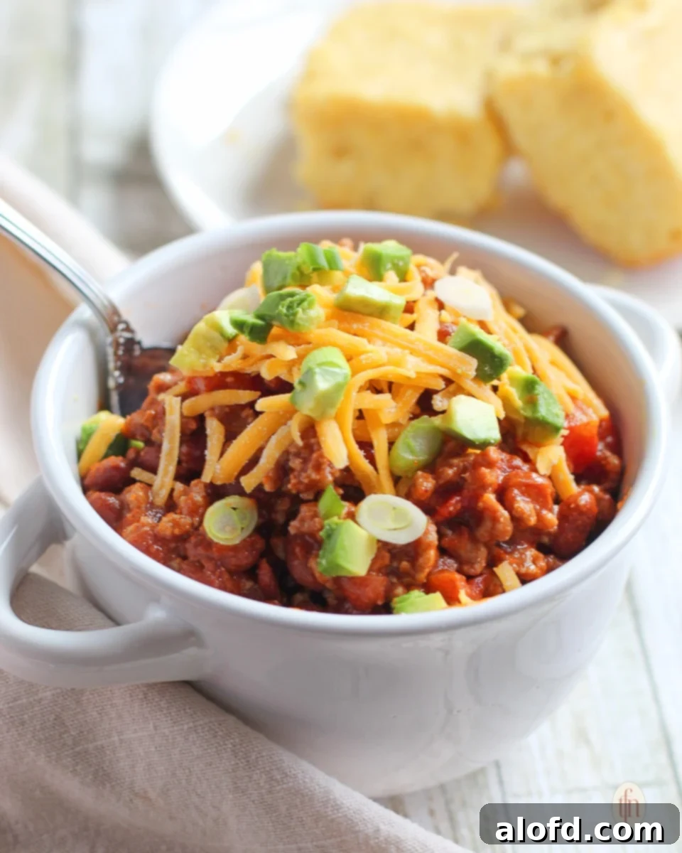Hearty Skillet Chili 2 Chili con carne and a spoon in a small bowl with 2 pieces of cornbread.