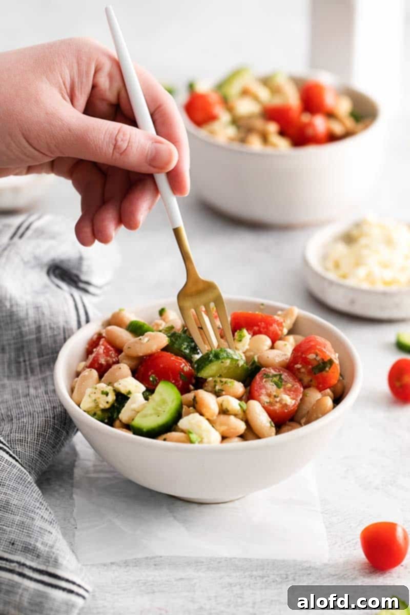 Vibrant Italian Bean Medley 4 A large white bowl filled with Italian white bean salad, garnished with fresh parsley.