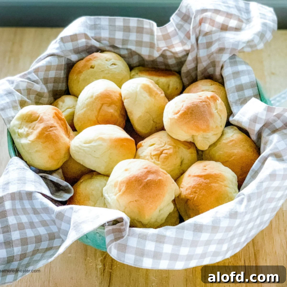 Rustic Sourdough Buns 11 Sourdough rolls on a kitchen towel wrapped bowl.