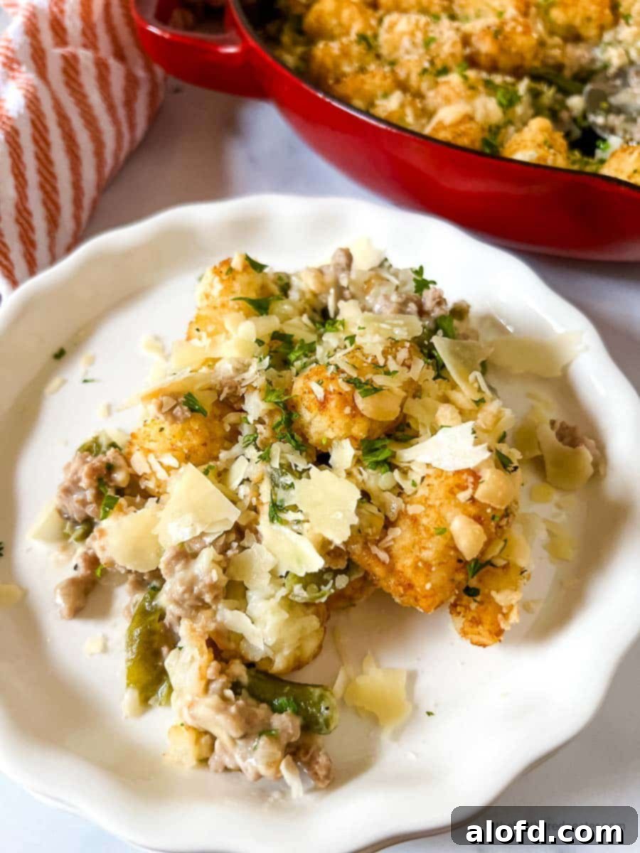 Savory Turkey Tater Bake 10 a plate with turkey tater tots and red striped cloth and a skillet in the background.