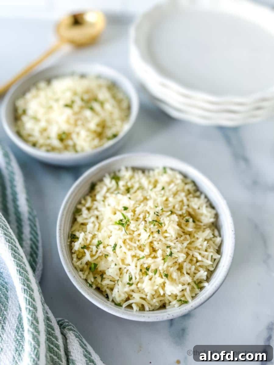 Perfect Instant Pot Basmati Rice 2 Two white bowls of Instant Pot Rice with a stack of white plates, striped cloth, and golden serving spoon at the background.
