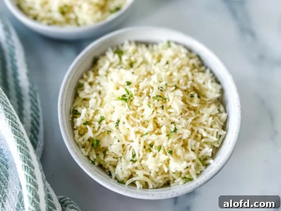 Perfect Instant Pot Basmati Rice 11 Two white bowls of Instant Pot Basmati Rice with a stack of white plates and golden serving spoon at the background.