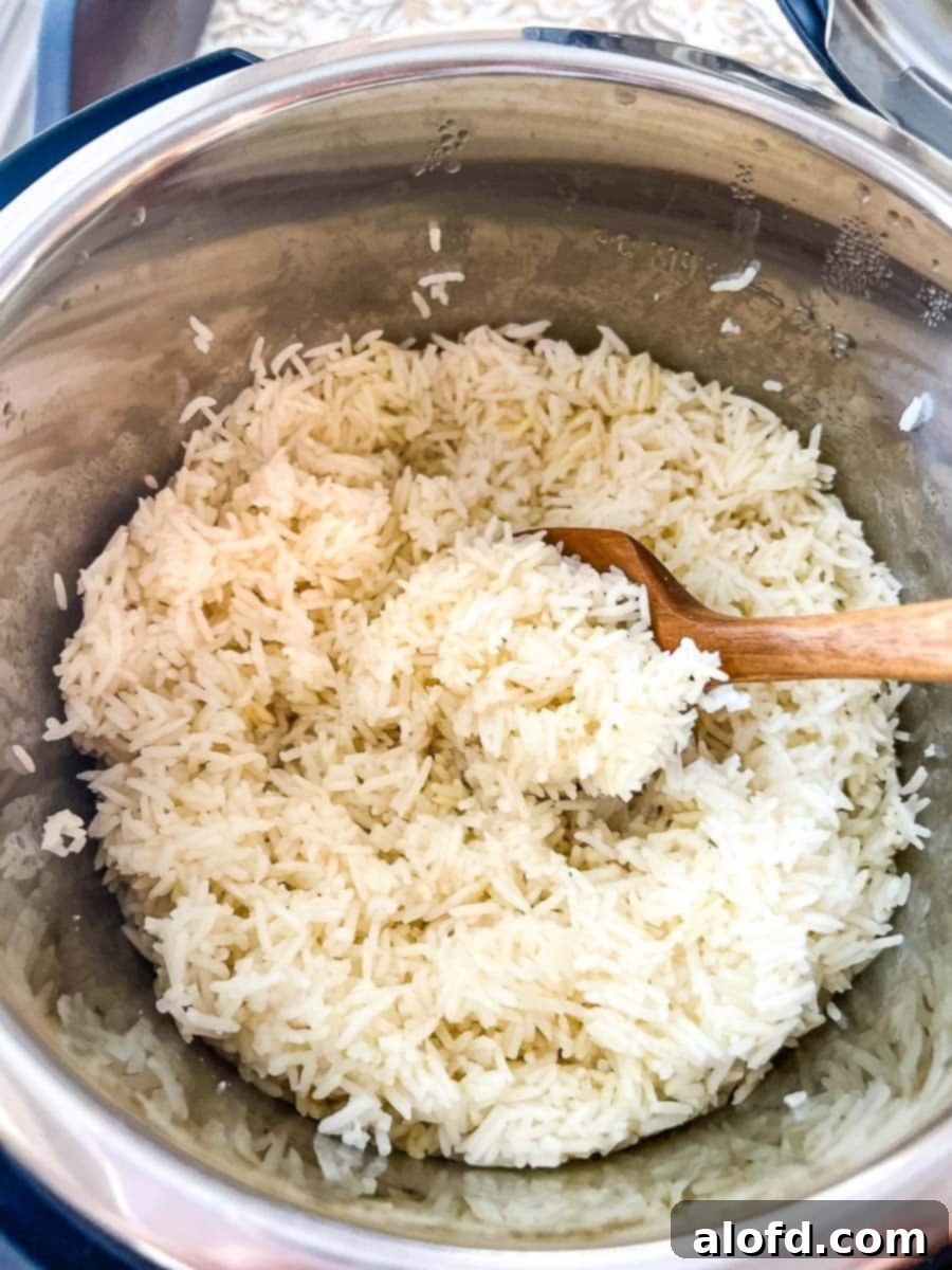 Perfect Instant Pot Basmati Rice 8 Cooked Basmati Rice in an Instant Pot with a wooden spoon.