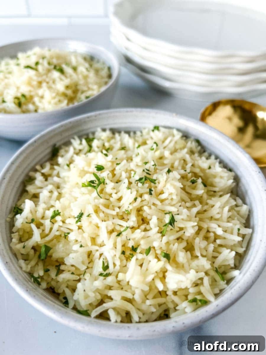 Perfect Instant Pot Basmati Rice 10 Two white bowls of Instant Pot Basmati Rice with a stack of white plates and golden serving spoon at the background.