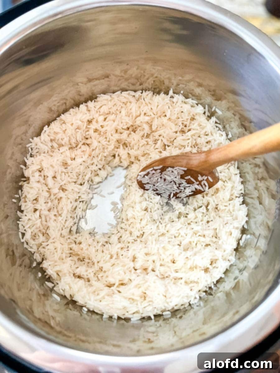 Close-up of jasmine rice being gently sautéed in the Instant Pot, turning slightly golden and fragrant.