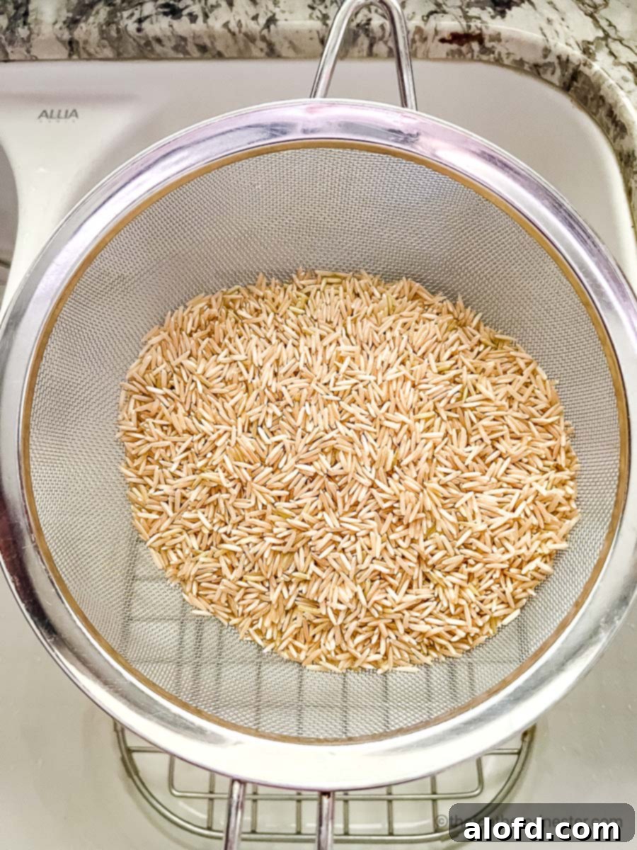 Fluffy Instant Pot Brown Basmati Rice 4 Dry brown basmati rice being rinsed in a mesh colander.