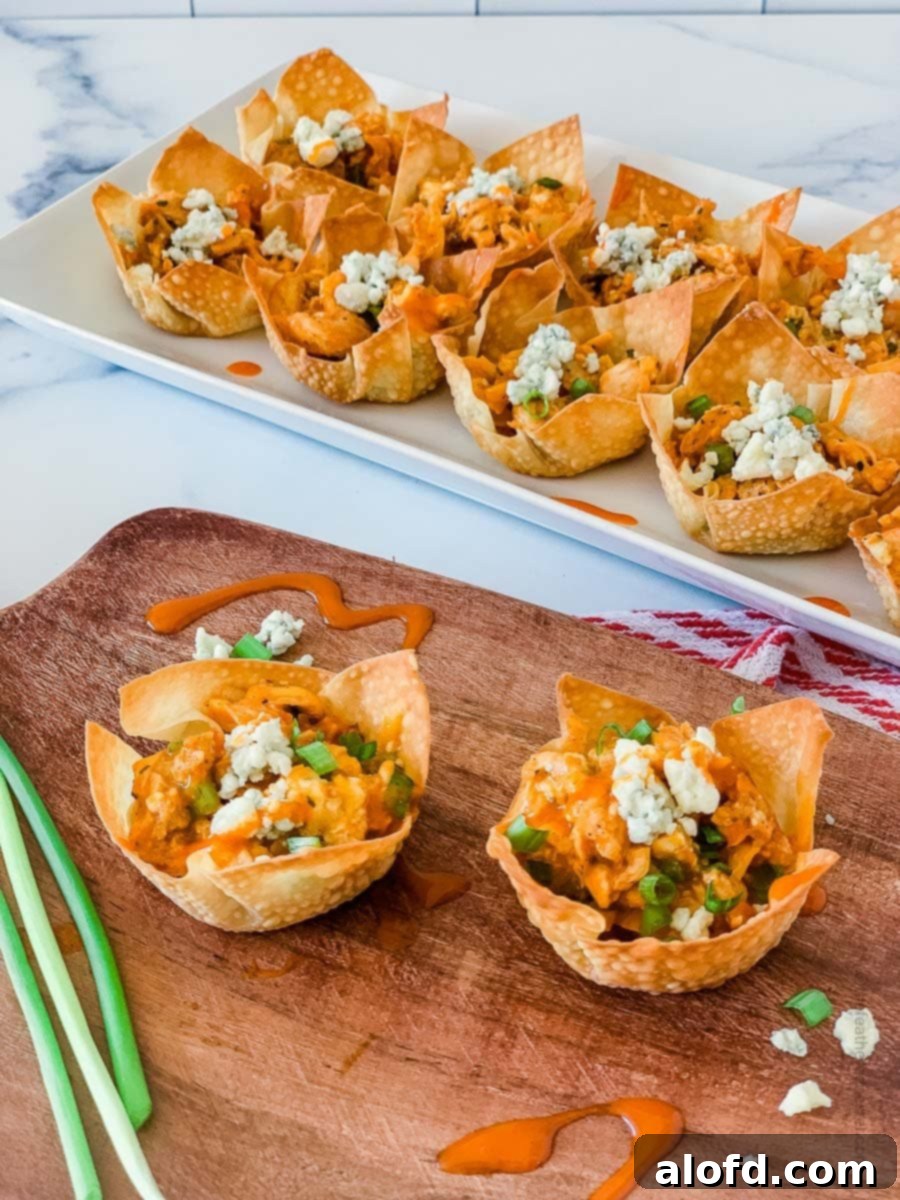 Crispy Baked Wonton Delights 3 Buffalo chicken appetizers placed on a wooden serving tray and white serving platter.