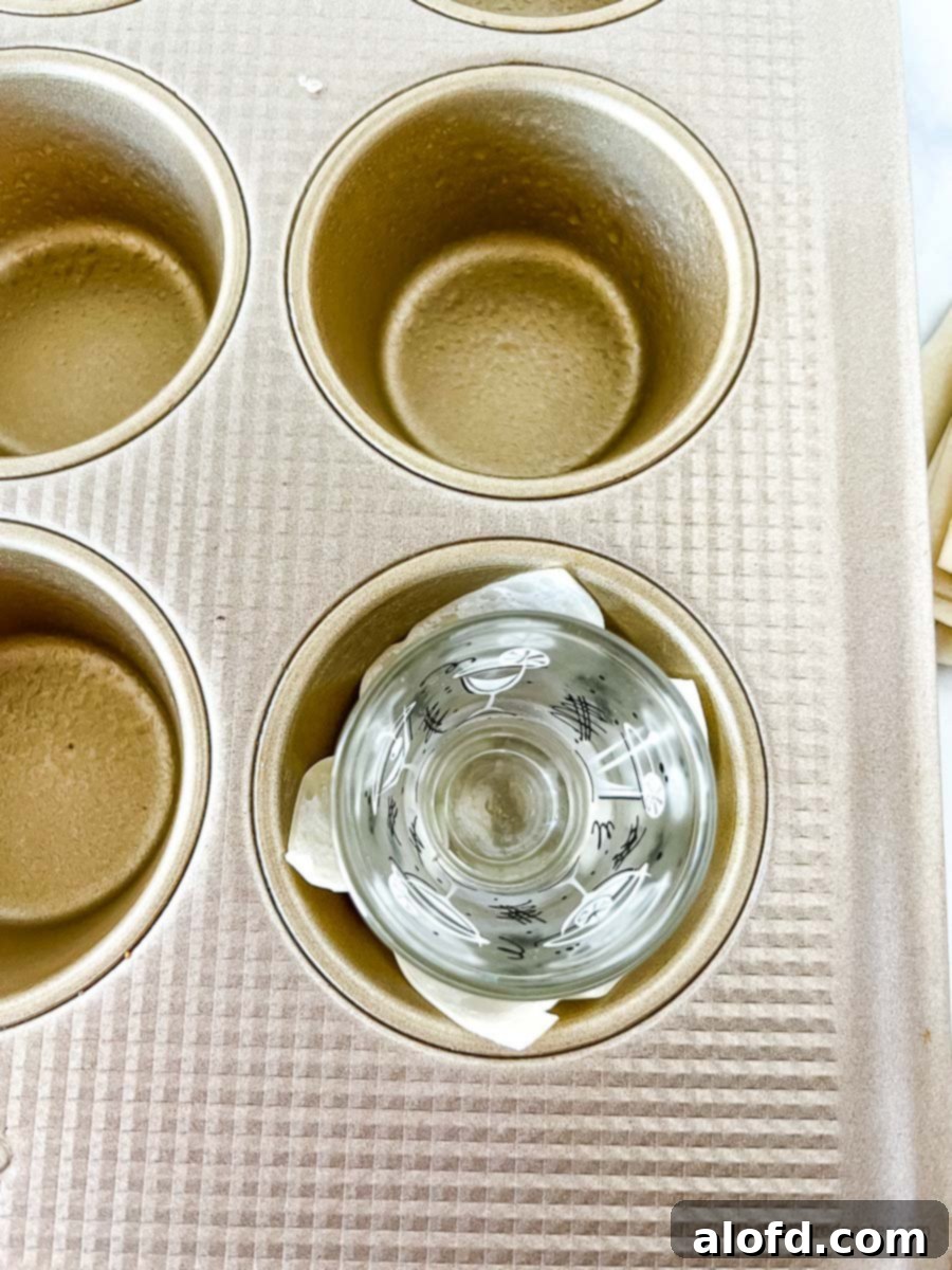 Crispy Baked Wonton Delights 5 Muffin pans with wonton wrappers being shaped by a shot glass.