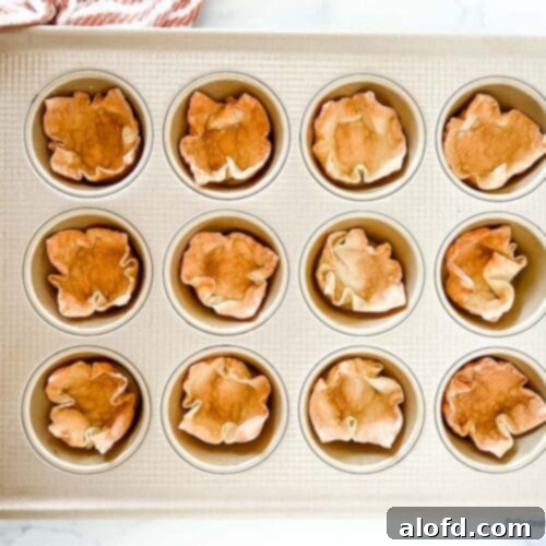 Crispy Baked Wonton Delights 9 A muffin tin with baked wonton wrapper cups, with a striped red cloth at the side.