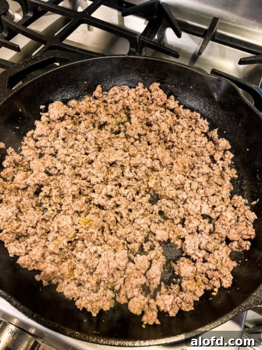 Crispy Taco Wonton Bites 7 A cast iron skillet filled with perfectly browned ground beef, seasoned and ready for the next step of the taco wonton cup recipe.