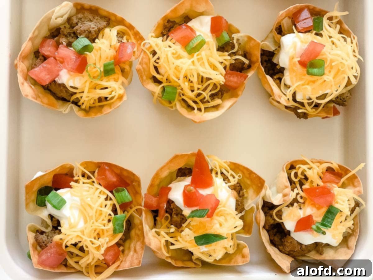 Crispy Taco Wonton Bites 10 A white tray showcasing a cluster of taco wonton cups, perfectly golden and filled, invitingly arranged.