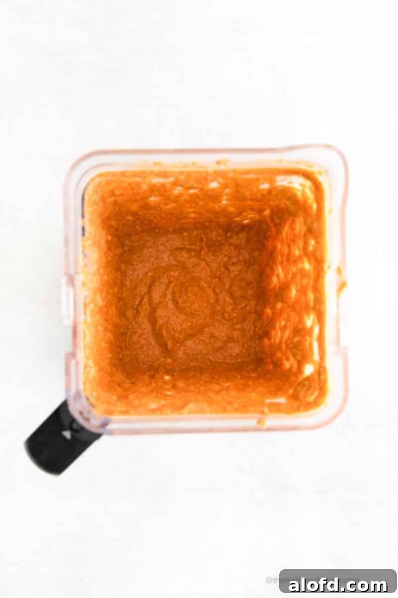 The blended ingredients for pumpkin baked oatmeal, showcasing a smooth, thick, and uniformly textured batter inside a high-speed blender jar.