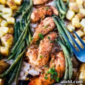 oven baked marinated chicken tenders with asparagus and potatoes beside it.
