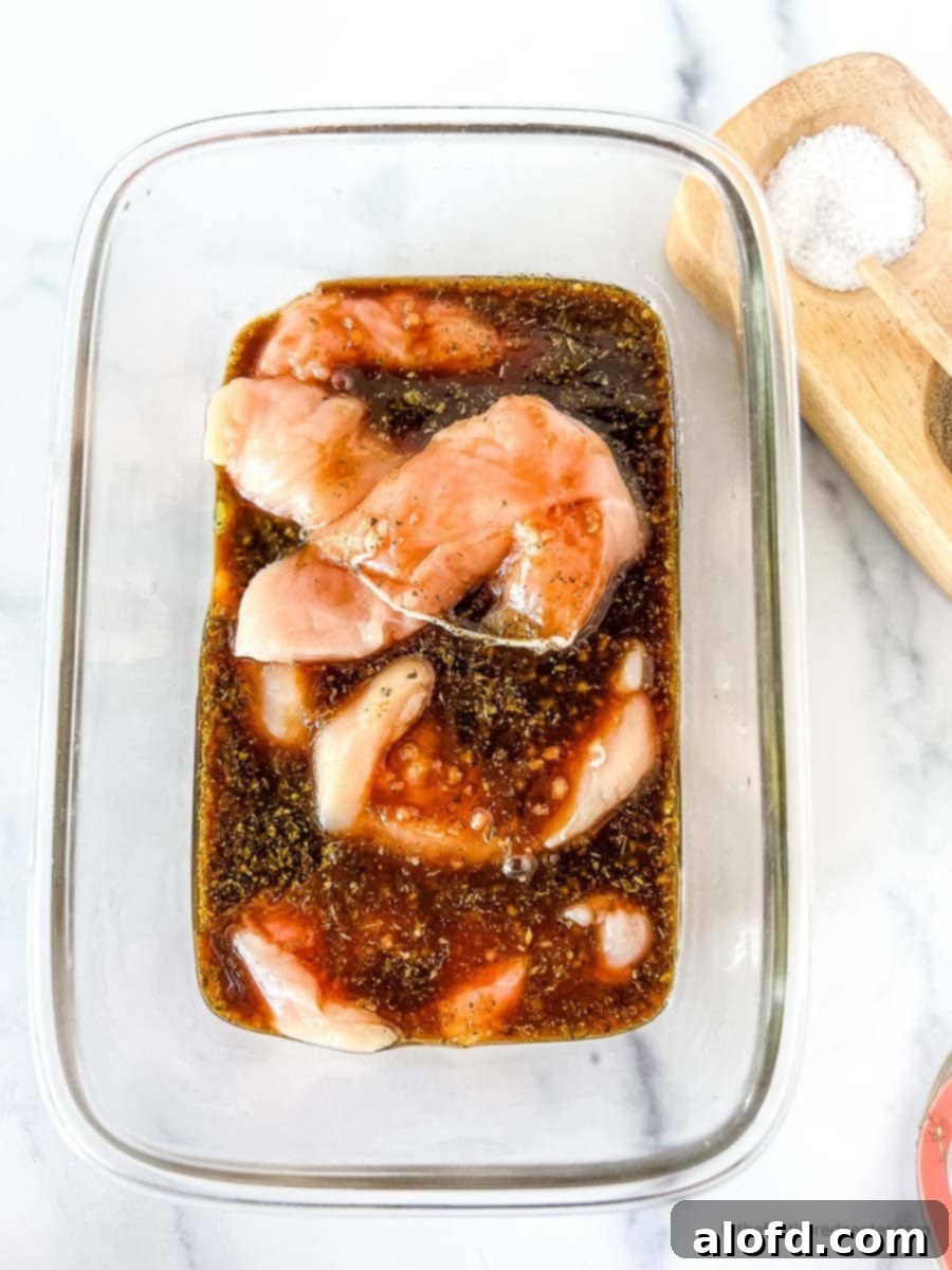 Sweet and Tangy Balsamic Chicken Marinade 3 A glass container with a marinated chicken.