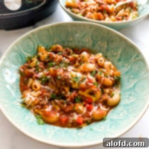 National Pasta Day: Your Ultimate Pasta Feast 3 Instant Pot goulash in a vibrant green serving bowl, topped with fresh herbs.