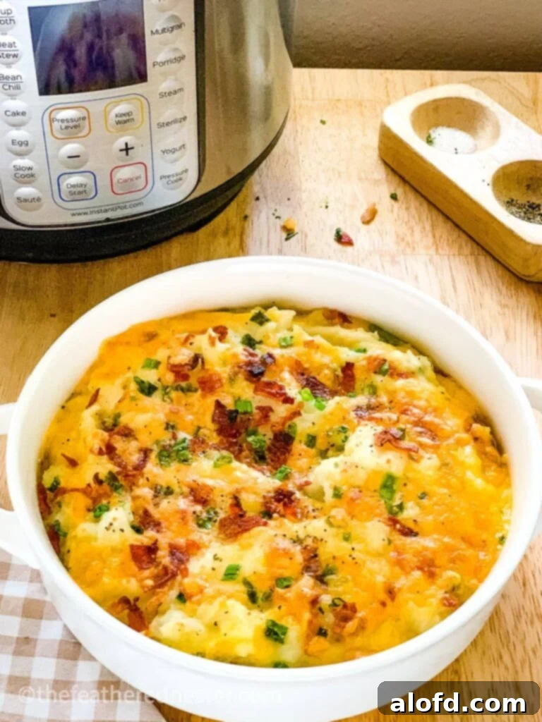 Our Top 5 Thanksgiving Dinner Recipes 11 A serving bowl filled with creamy loaded potatoes, topped with melted cheese, crispy bacon bits, and fresh green onions.