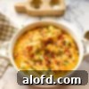 Our Top 5 Thanksgiving Dinner Recipes 12 A round casserole dish showcasing a delicious loaded potato casserole, golden and bubbly, ready to serve.