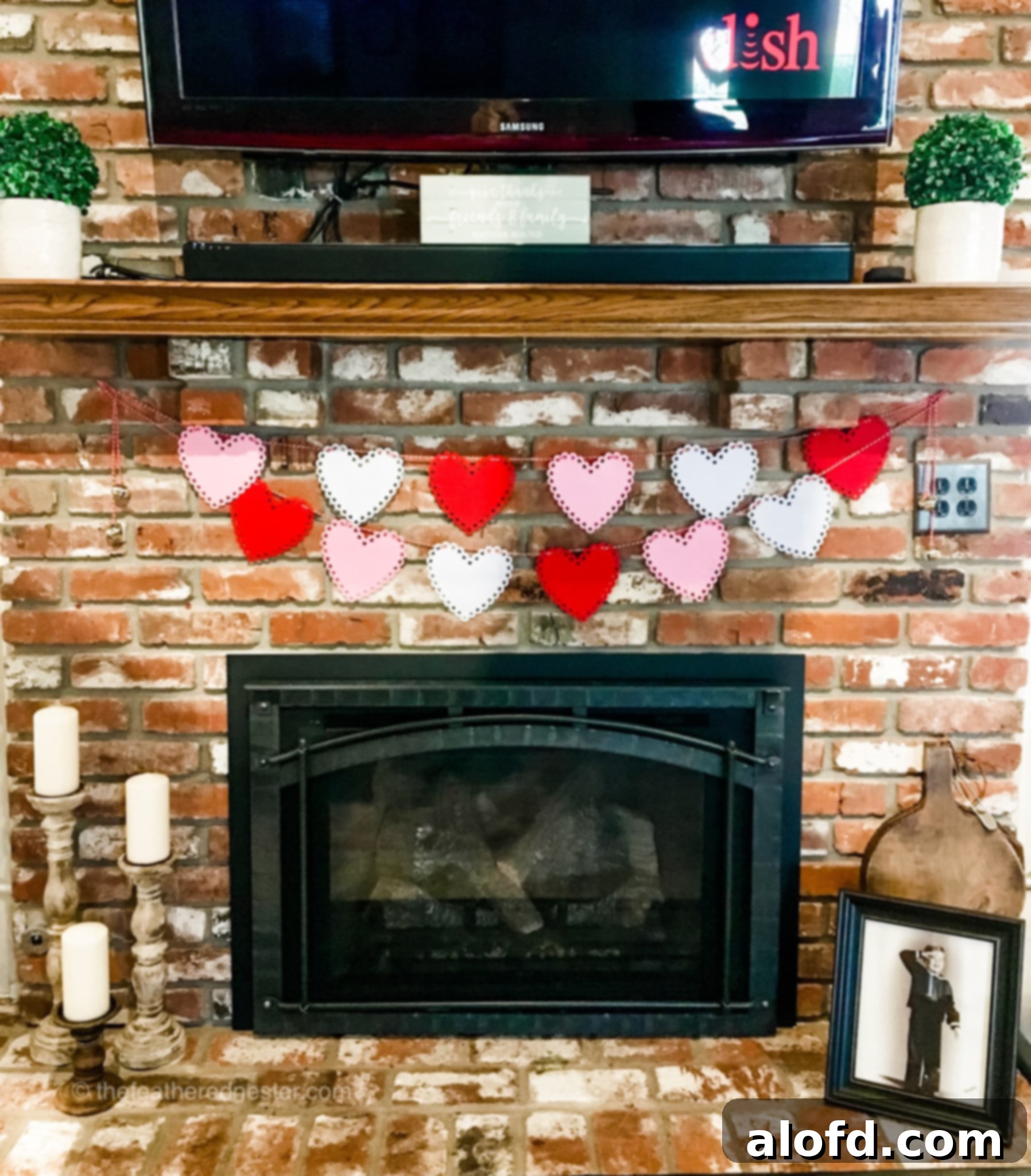 Valentine's Day DIY fabric garland on a brick wall, featuring bells.