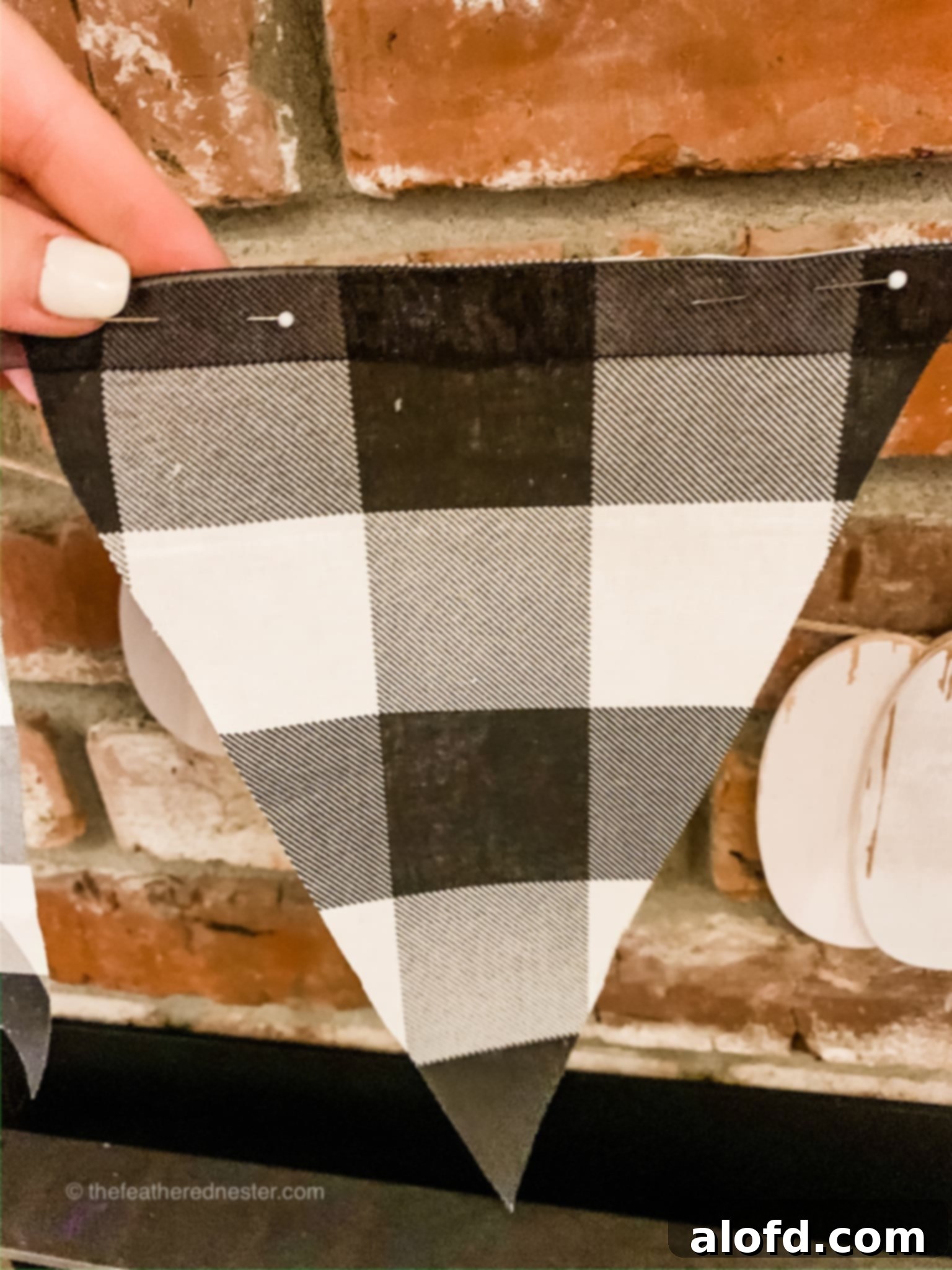 Close-up of buffalo plaid fabric garland with a pin, ready for attachment.