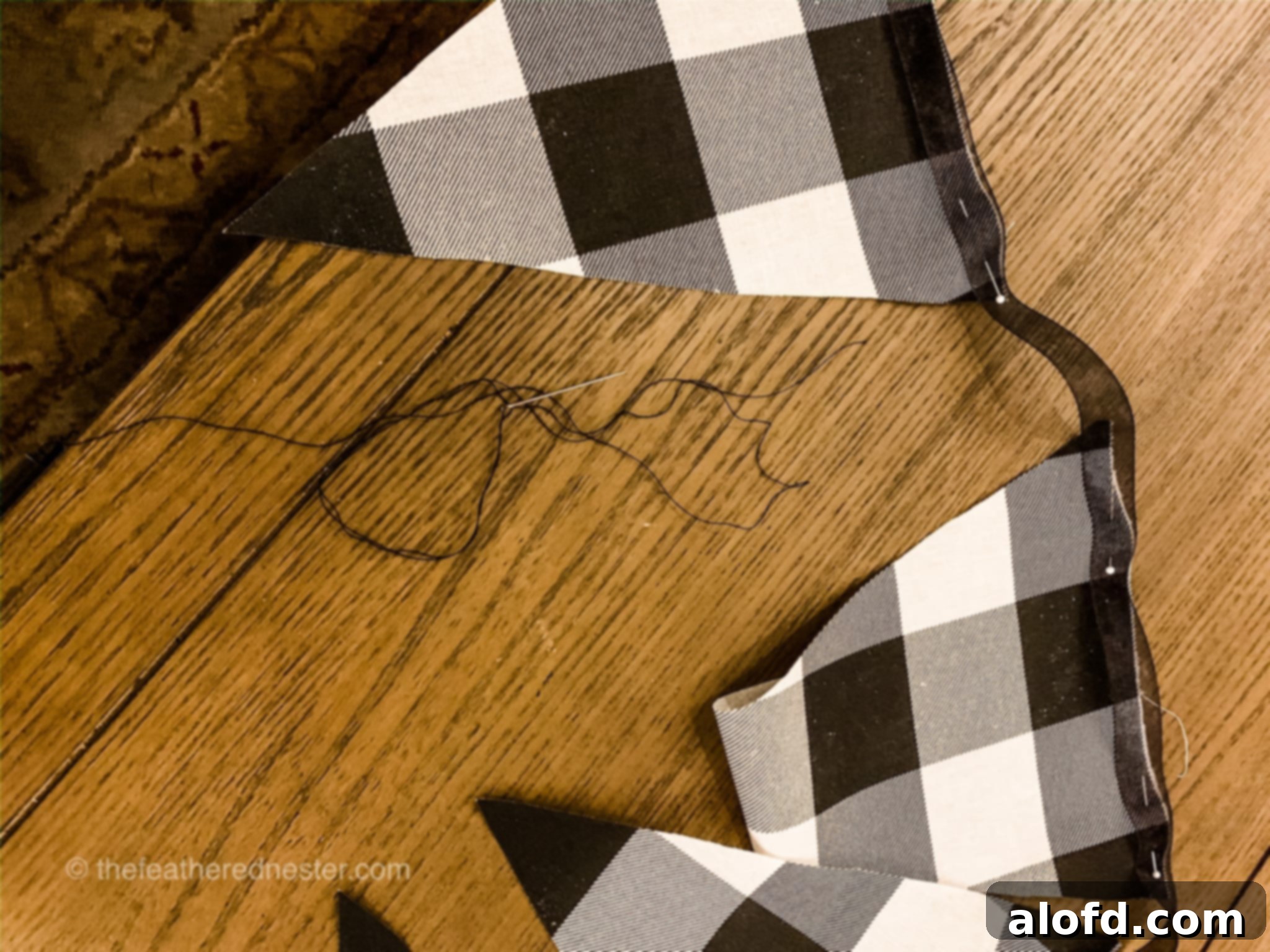 Buffalo plaid fabric garland on a table with pins, during the assembly phase.