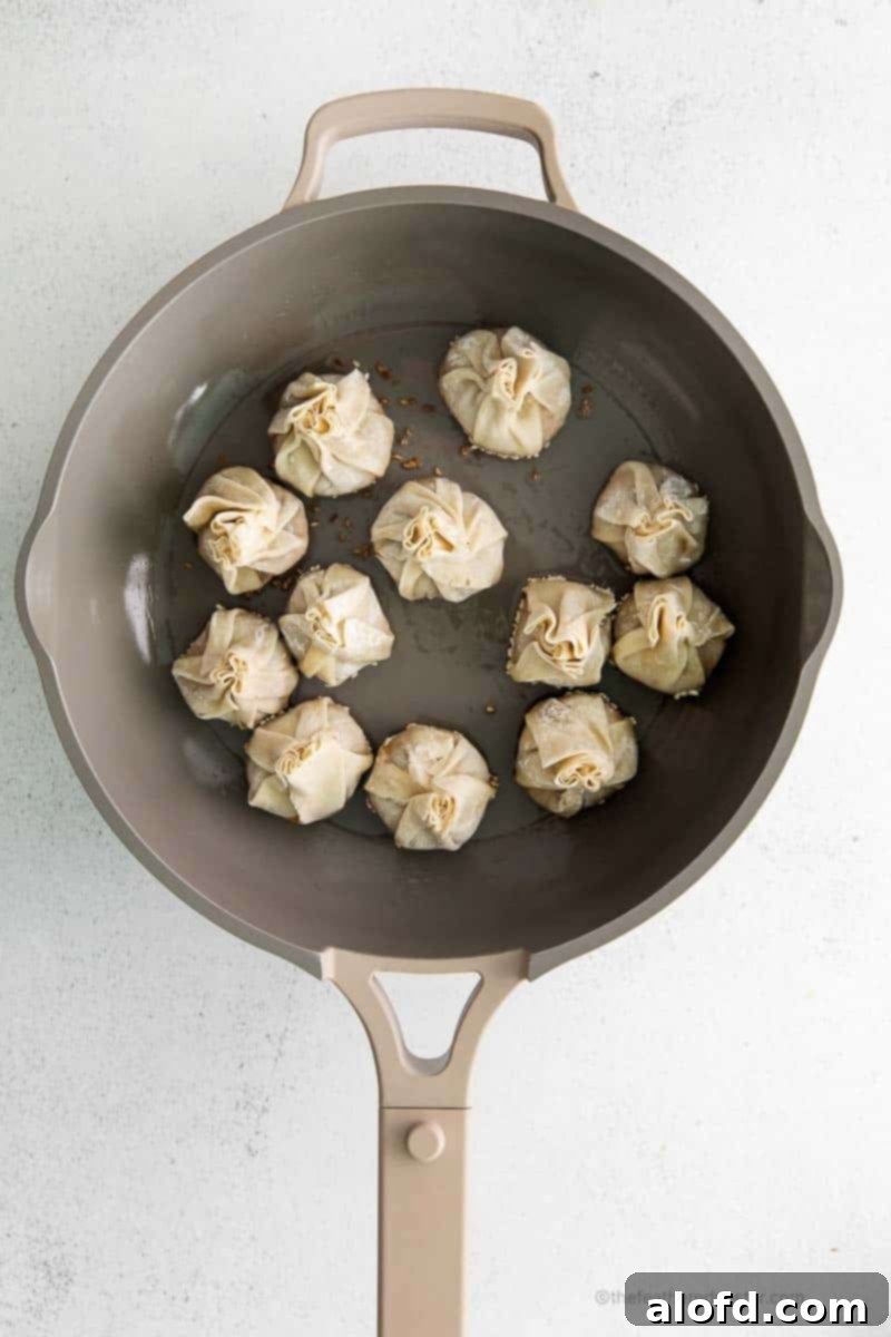 Umami Mushroom Pockets 11 A vivid scene of mushroom vegetarian dumplings actively cooking in a skillet, capturing the sizzle and transformation during pan-frying.