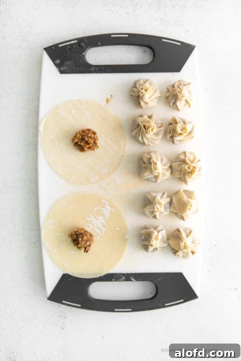 Umami Mushroom Pockets 9 A close-up of hands meticulously wrapping the mushroom vegetarian dumpling mixture in delicate wonton wrappers, demonstrating the precise folding process.