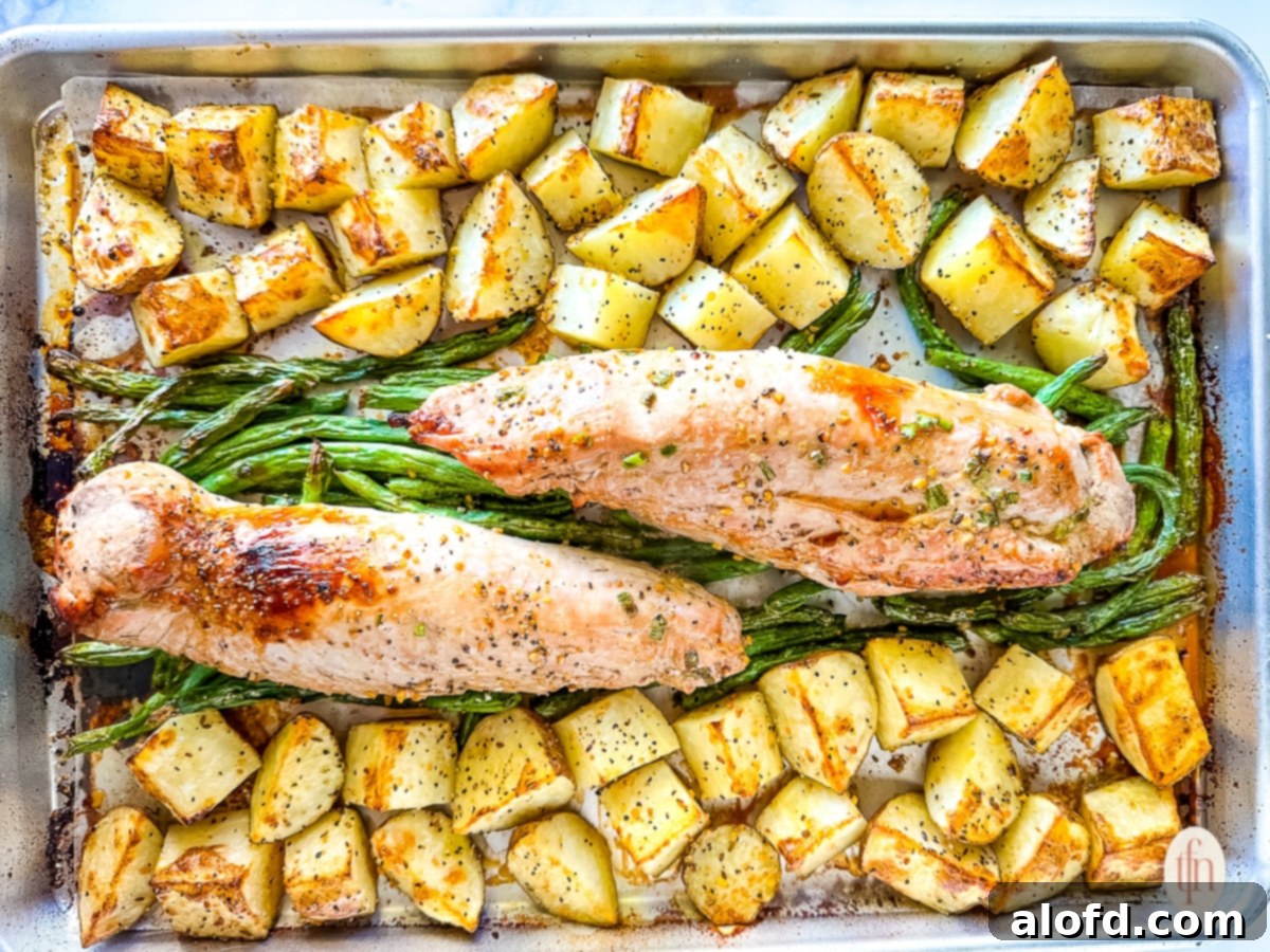 Effortless Sheet Pan Pork Tenderloin 9 Sheet pan pork tenderloin dinner, after roasting in the oven.