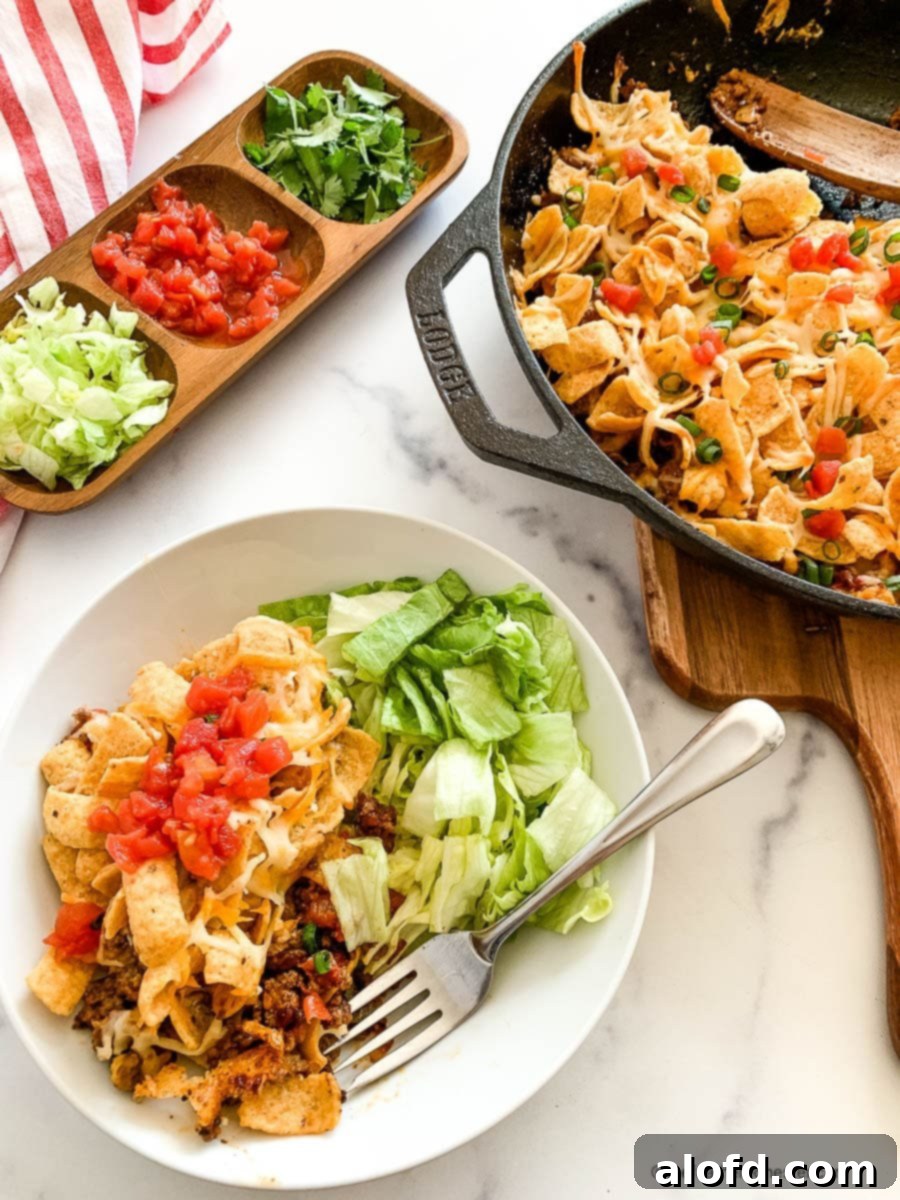 Dozens of Delightful Family Meals Under Ten Bucks 3 Walking taco casserole on a white dinner plate and in a skillet next to the plate.