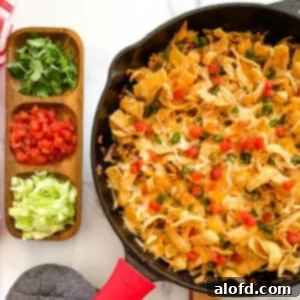 Loaded Taco Bake 11 Walking taco casserole with Fritos in a skillet, accompanied by dishes of fresh toppings on the side, highlighting its customizable appeal.