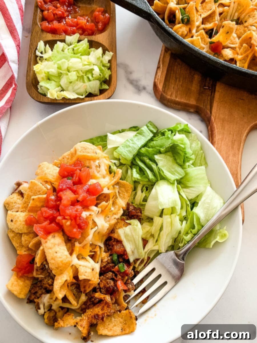 Loaded Taco Bake 5 A perfectly portioned serving of walking taco bake presented on a small white plate, ready to be enjoyed.