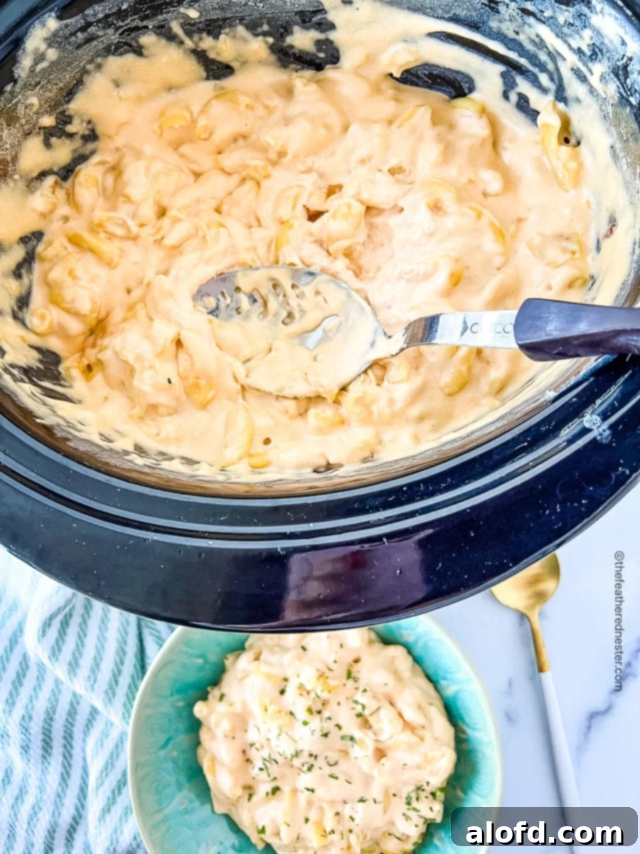 serving spoon in a pot full of cheesy pasta
